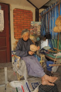 Sandots Mutter - jeden Tag sitzt sie von morgens bis abends vor dem Haus und flechtet Koerbe und Figuren aus Bambusblaettern